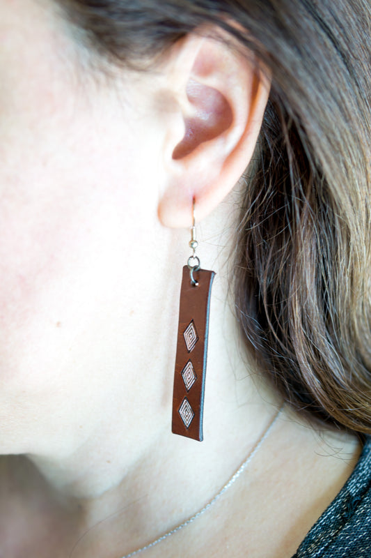 Brincos artesanais de couro formato barra – motivos abstratos castanho e lilás