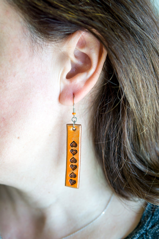 Brincos artesanais de couro formato barra – motivos abstratos laranja