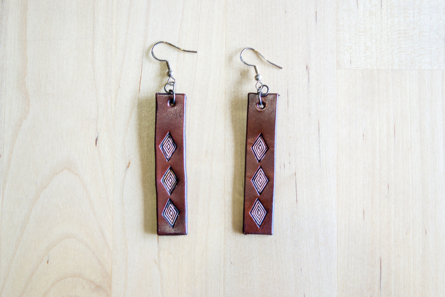 Brincos artesanais de couro formato barra – motivos abstratos castanho e lilás