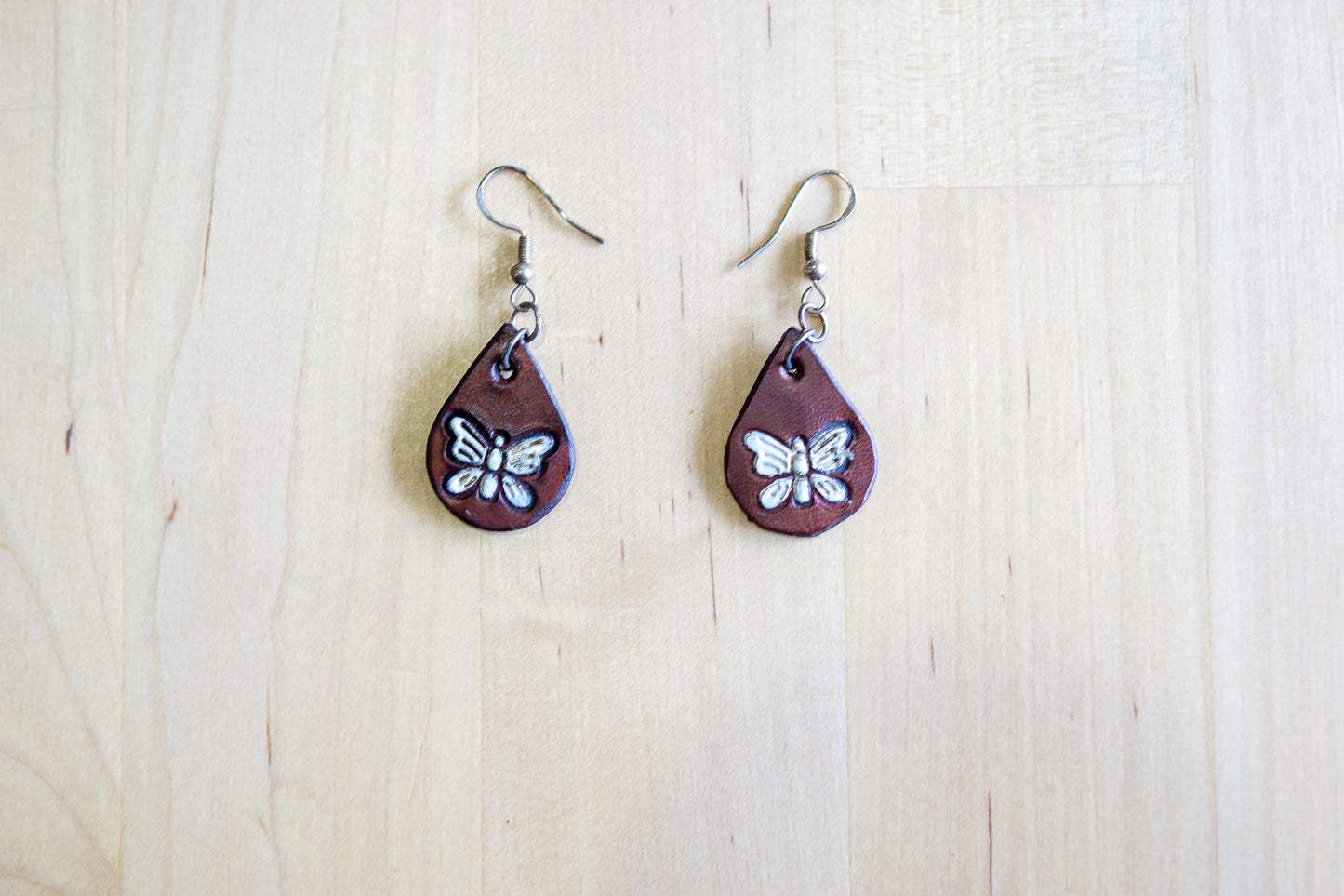 Brincos Artesanais em Couro – Gota com Borboleta Pintada à Mão (Castanho e Branco)